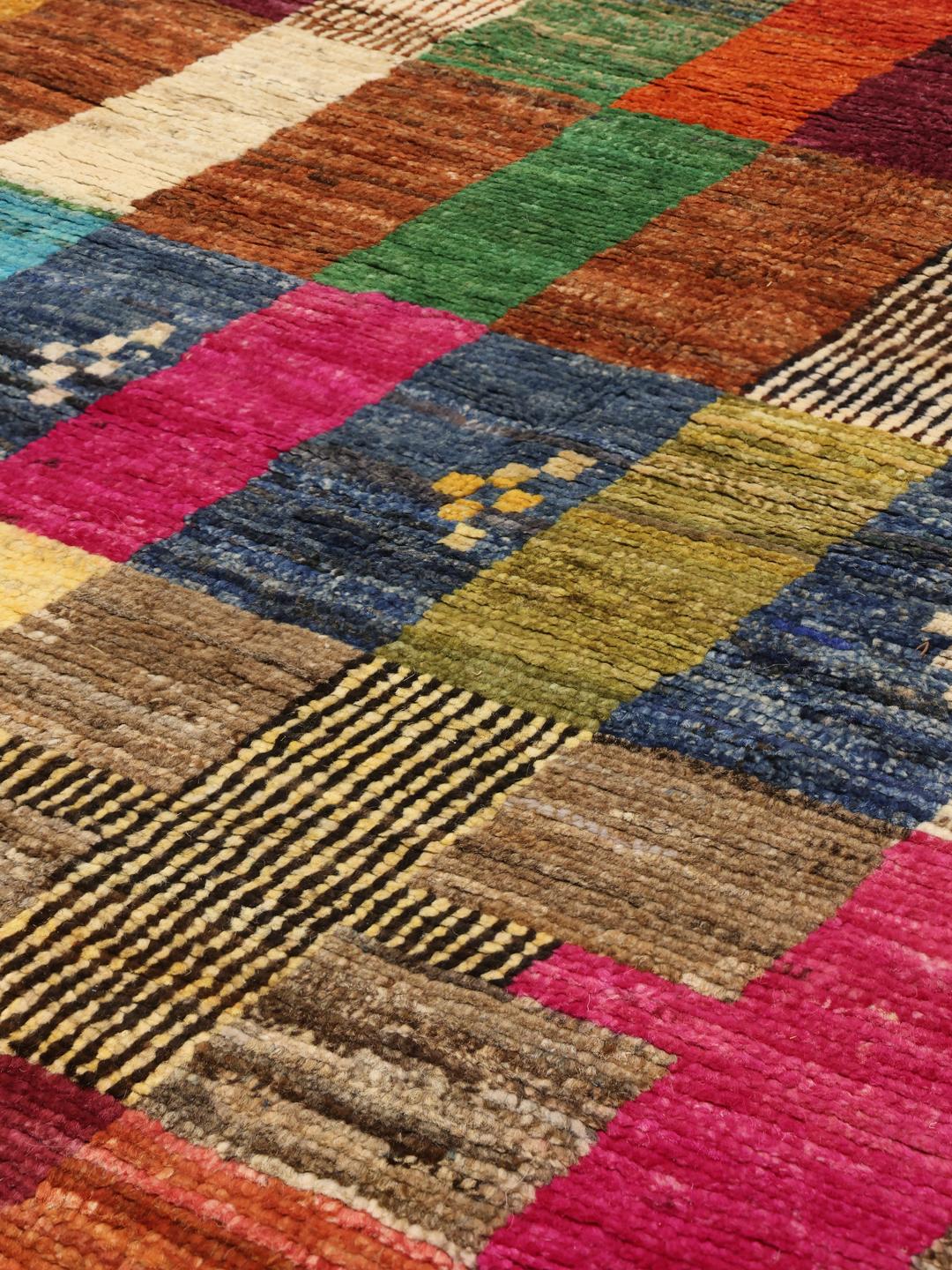 A vibrant, hand-knotted multicolor Berber-inspired rug from Afghanistan featuring a geometric grid design.