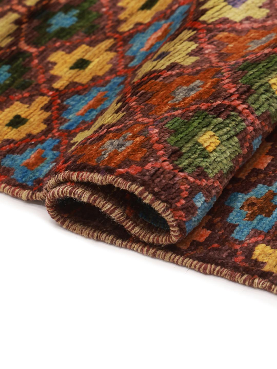 A vibrant, hand-knotted Berber rug from Afghanistan with a geometric multicolored design.