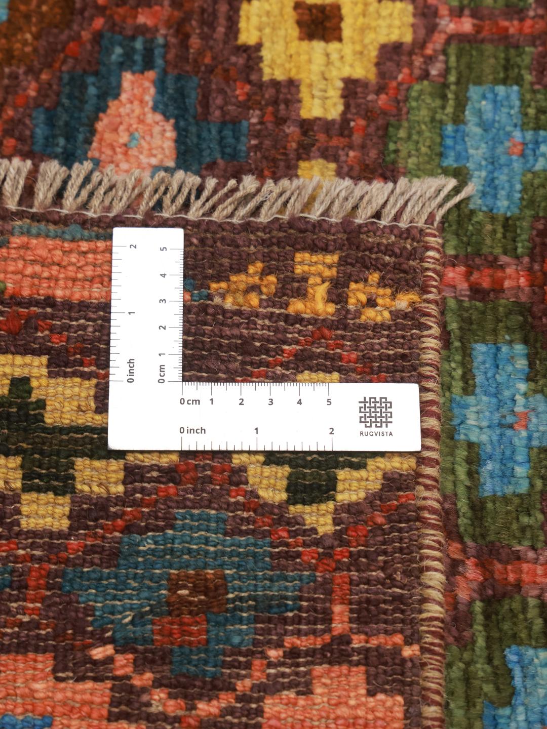 A vibrant, hand-knotted Berber rug from Afghanistan with a geometric multicolored design.