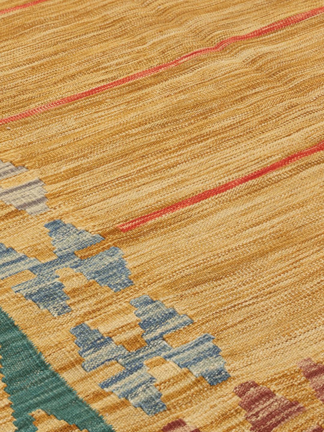 Un grand tapis Kelim Afghan tissé à la main présentant un champ jaune doré avec des rayures subtiles et des bordures géométriques décoratives.