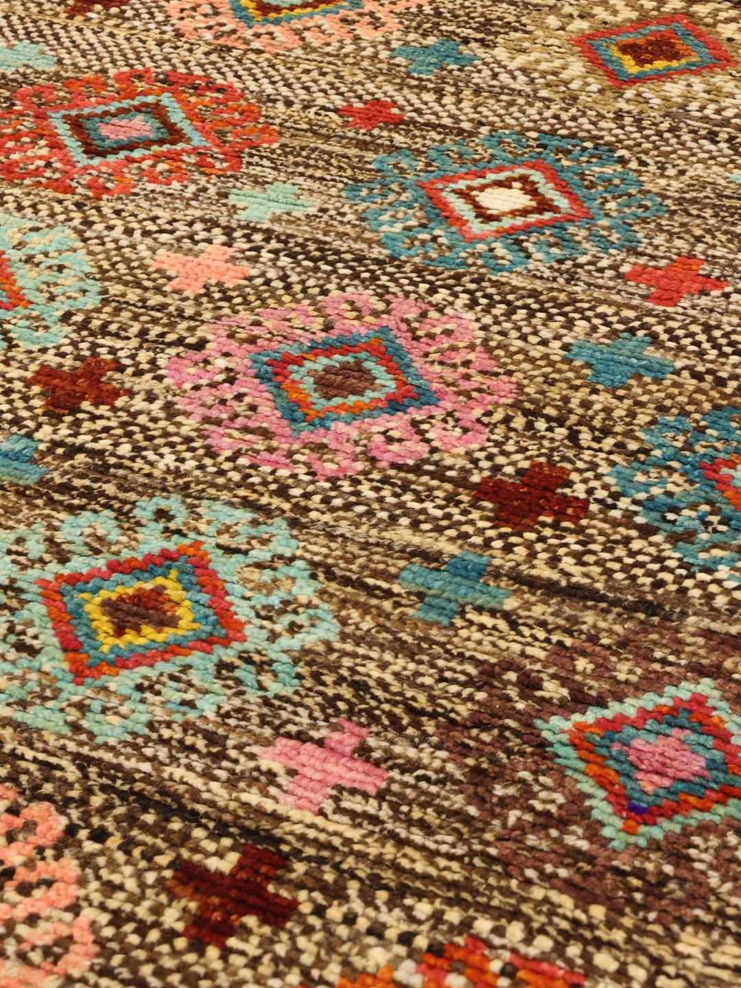 Håndknyttet afghansk Berber-tæppe med flerfarvede geometriske mønstre på en brun baggrund.