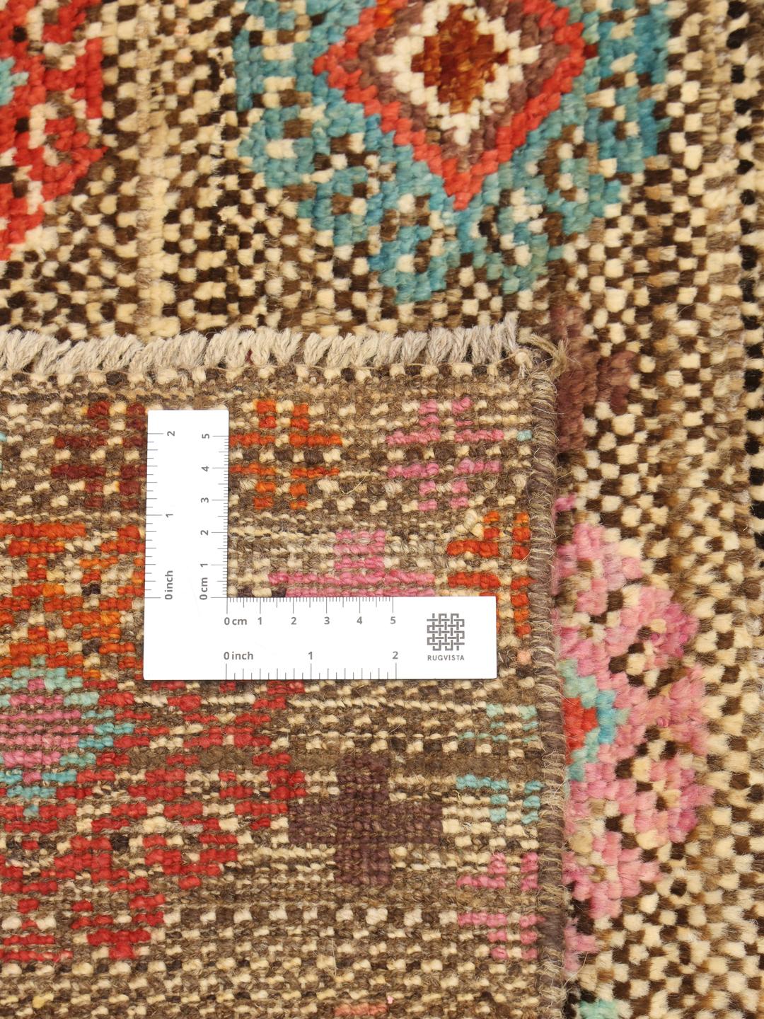 Håndknyttet afghansk Berber-tæppe med flerfarvede geometriske mønstre på en brun baggrund.
