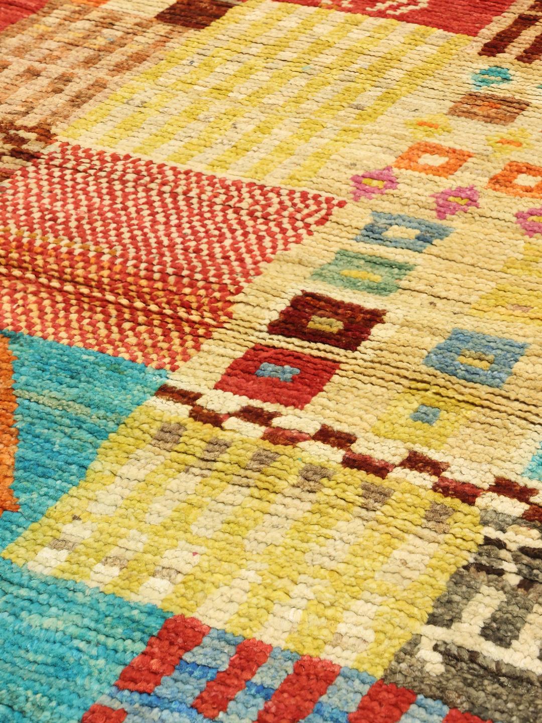 Een levendig, meerkleurig, handgeknoopt Berber-tapijt uit Afghanistan met geometrische blokken.