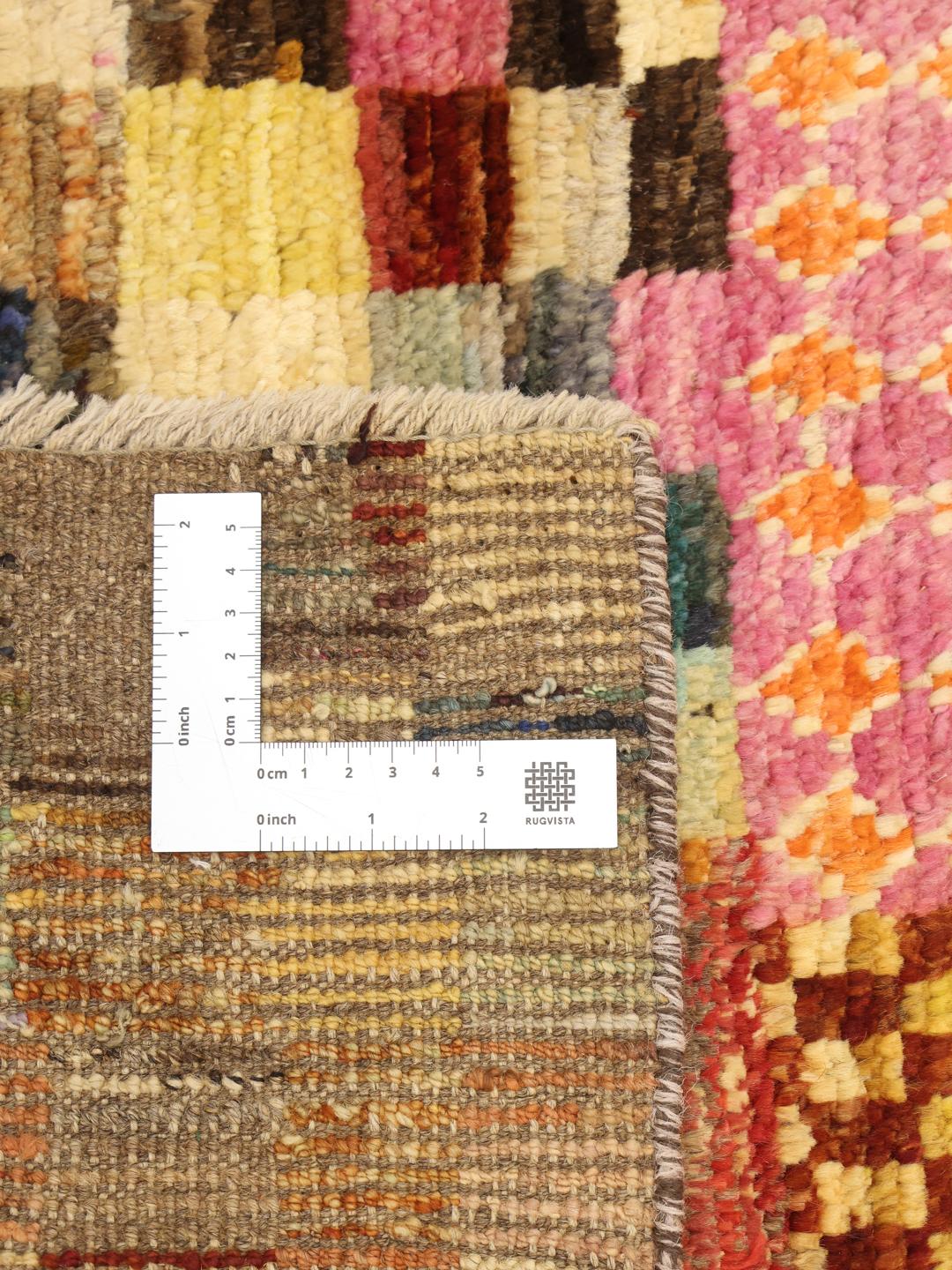 Een levendig, meerkleurig, handgeknoopt Berber-tapijt uit Afghanistan met geometrische blokken.