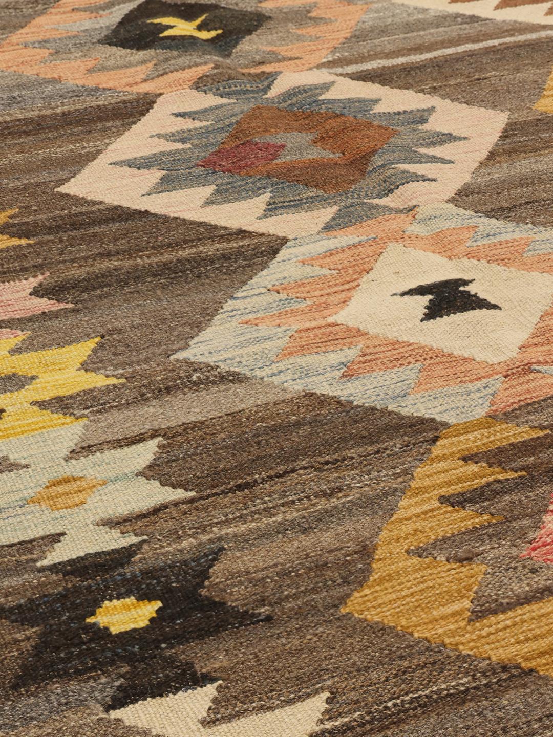 Hand-woven Afghan Kilim rug with geometric diamond patterns in brown, yellow, and blue tones