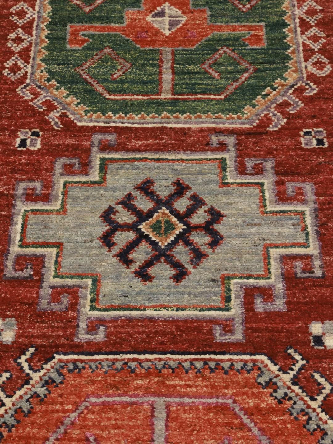 Handgeknoopte Kazak loper uit Afghanistan met levendige rode, groene en beige geometrische patronen.