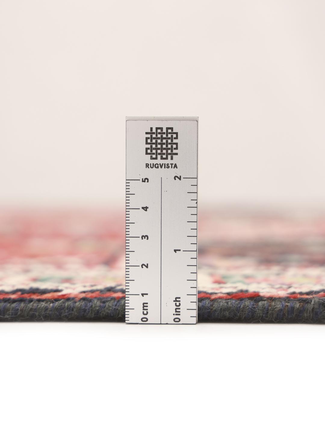 Hand-knotted Kazak rug from Afghanistan featuring red and black geometric patterns.