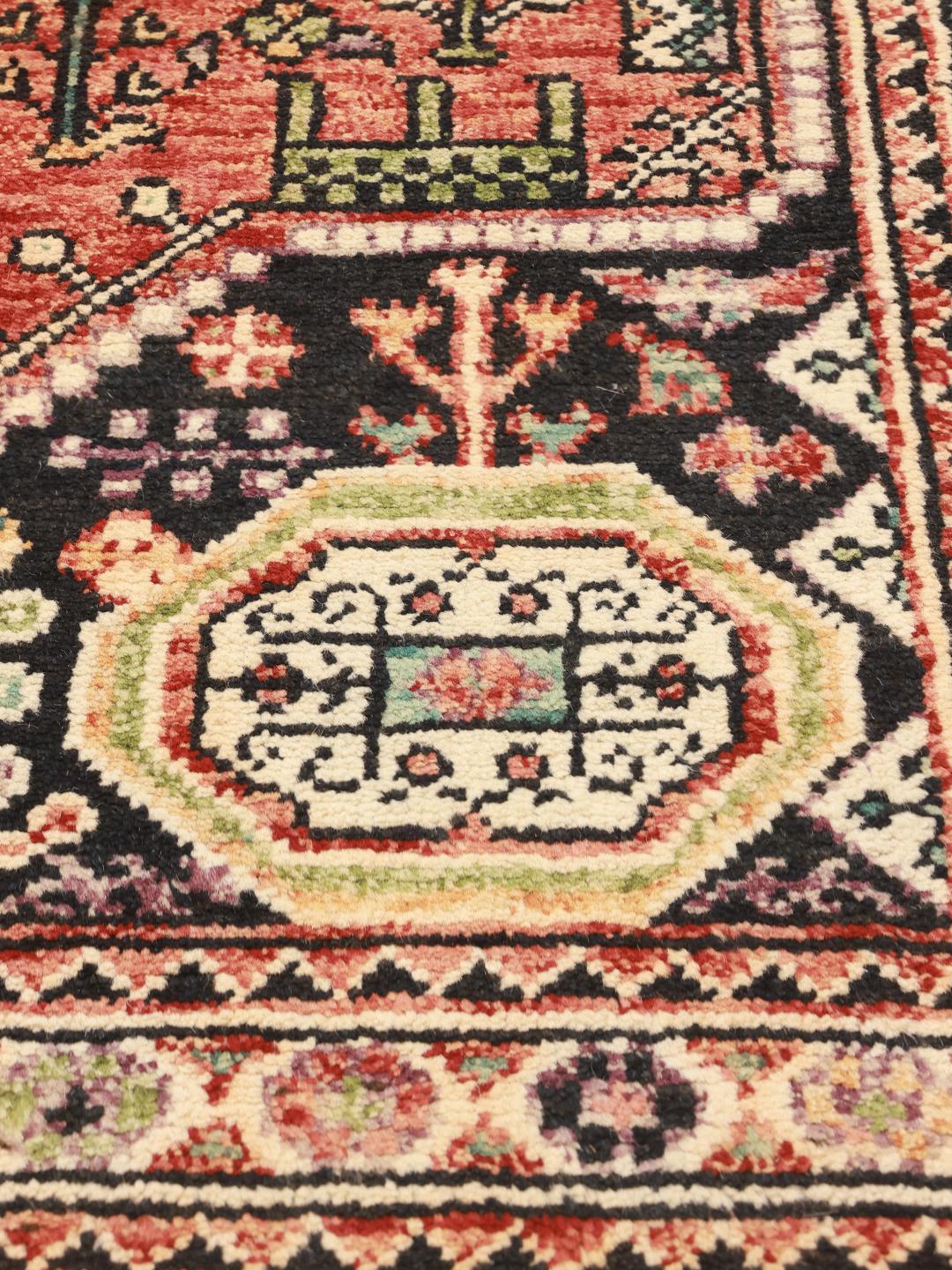 Hand-knotted Kazak rug from Afghanistan in deep red and black tones