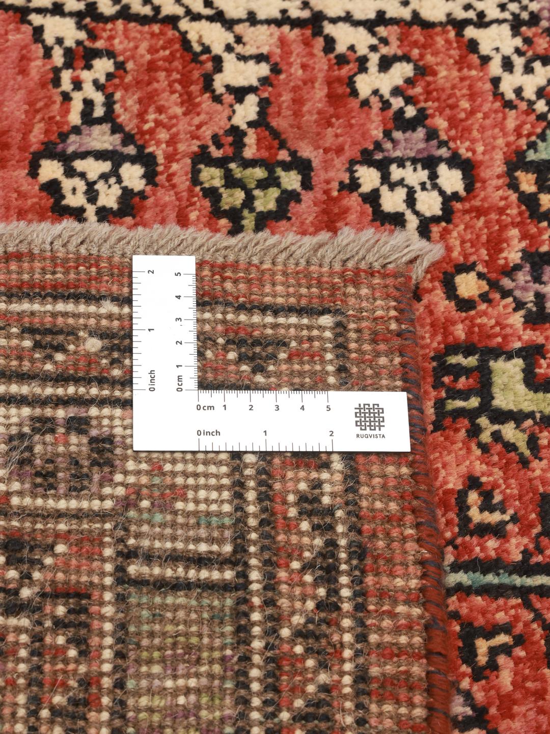 Hand-knotted Kazak rug from Afghanistan in deep red and black tones