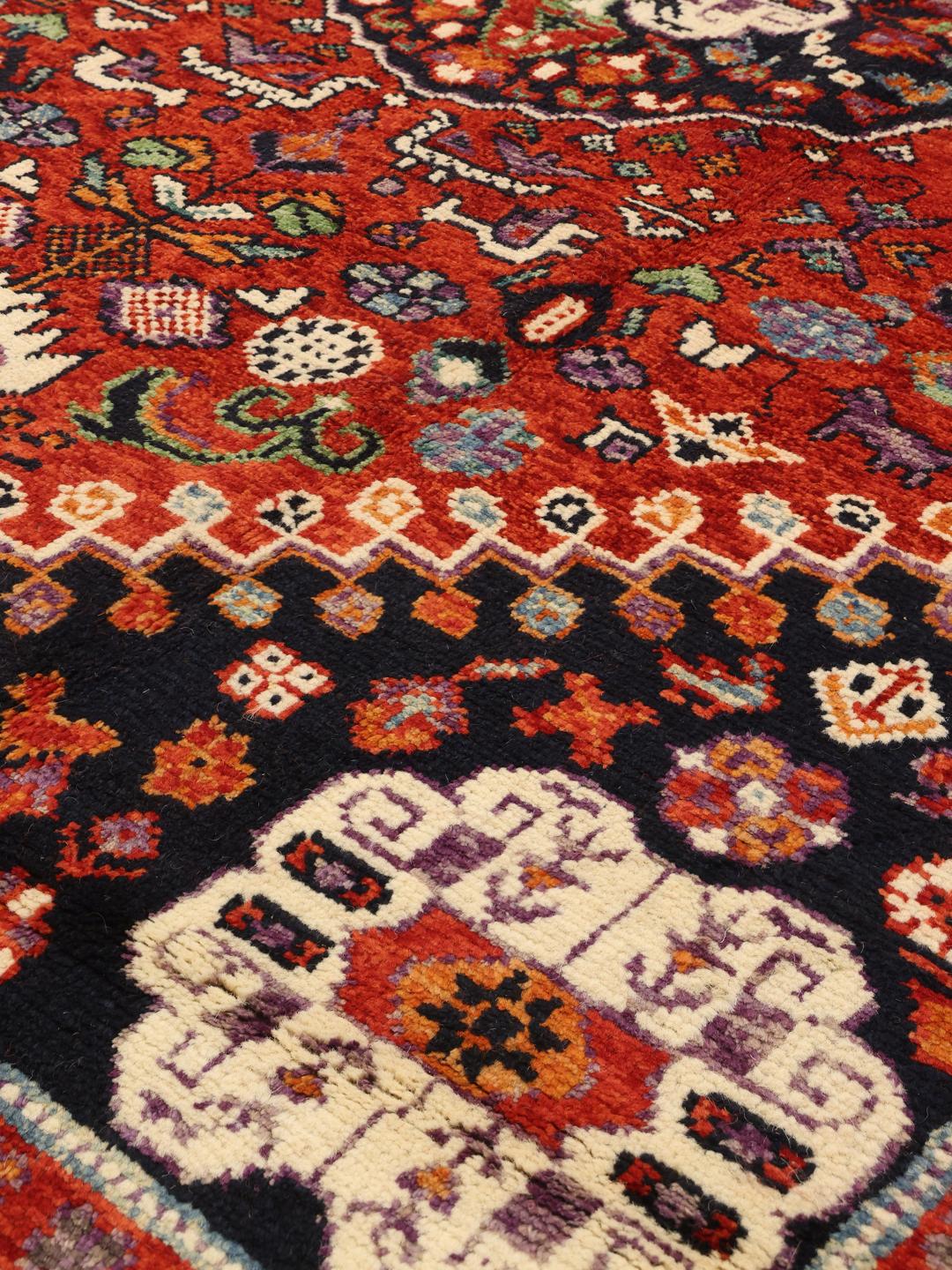 Hand-knotted Kazak rug from Afghanistan featuring a deep red and blue geometric design.