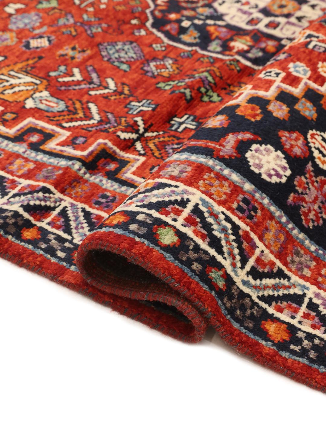 Hand-knotted Kazak rug from Afghanistan featuring a deep red and blue geometric design.