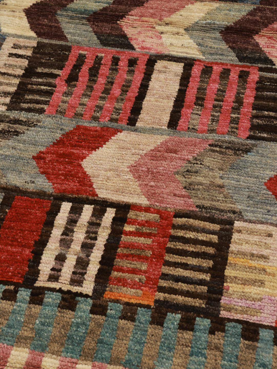 Un tapis couloir afghan vibrant et unique présentant des motifs géométriques multicolores et des bandes de rayures.