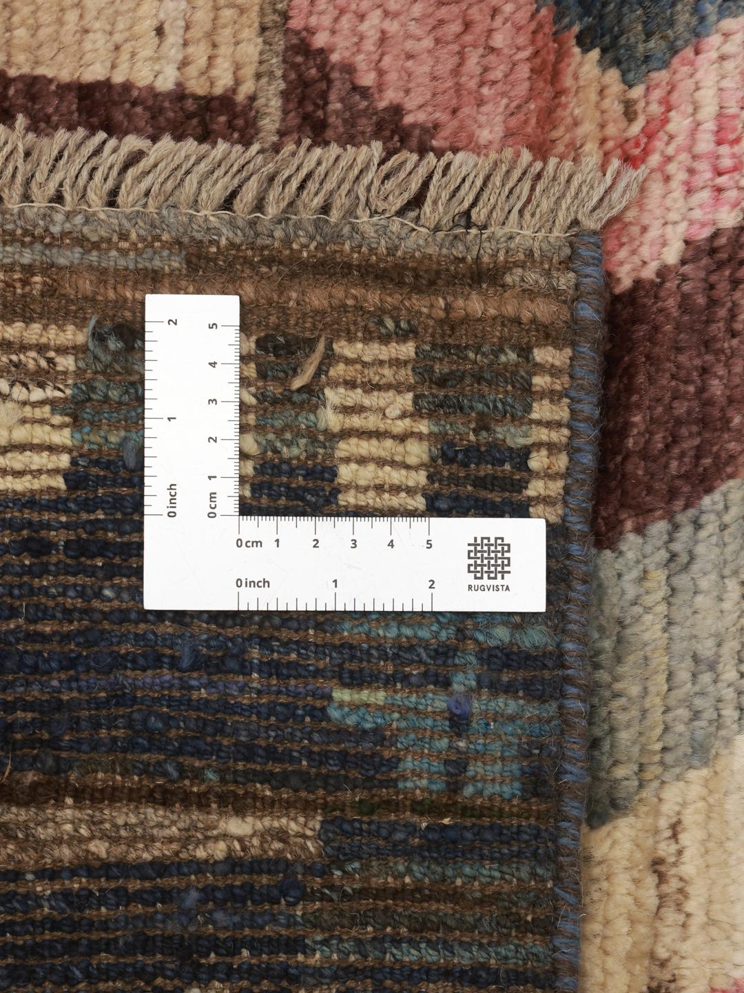 Un tapis couloir afghan vibrant et unique présentant des motifs géométriques multicolores et des bandes de rayures.