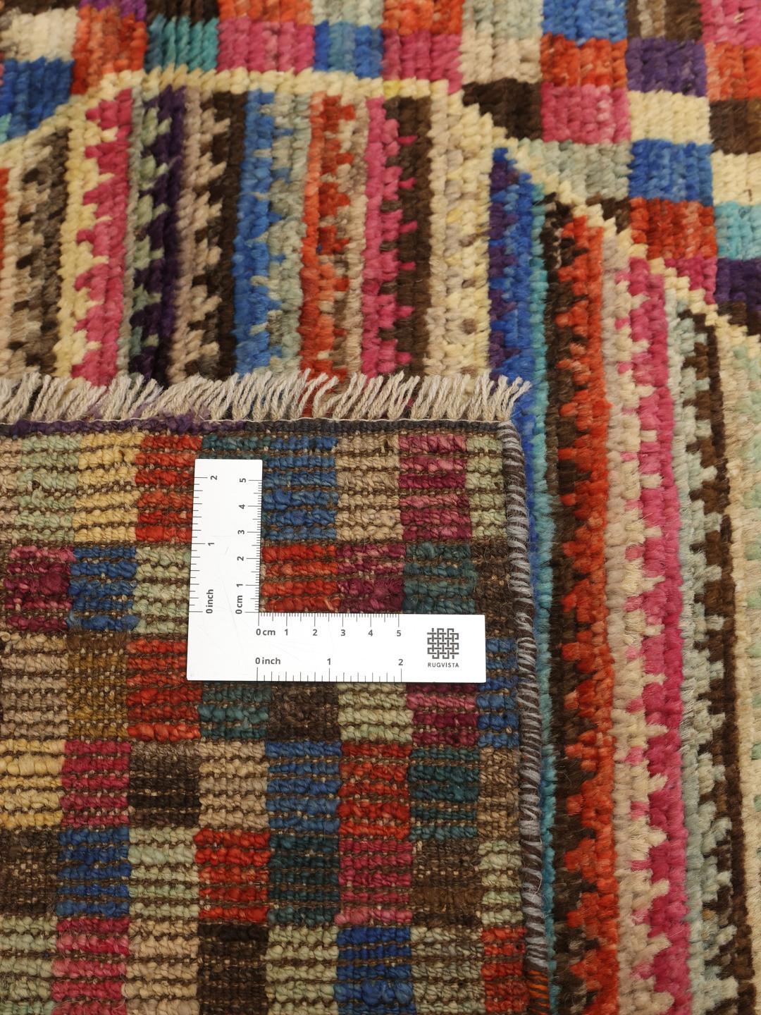 Een levendige handgemaakte wollen loper uit Afghanistan met een kleurrijk dambordpatroon en ruitmotieven.