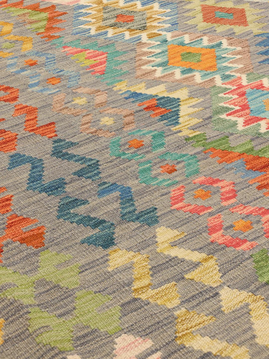 Hand-woven Kelim rug from Afghanistan with a multicolor geometric pattern on a grey background