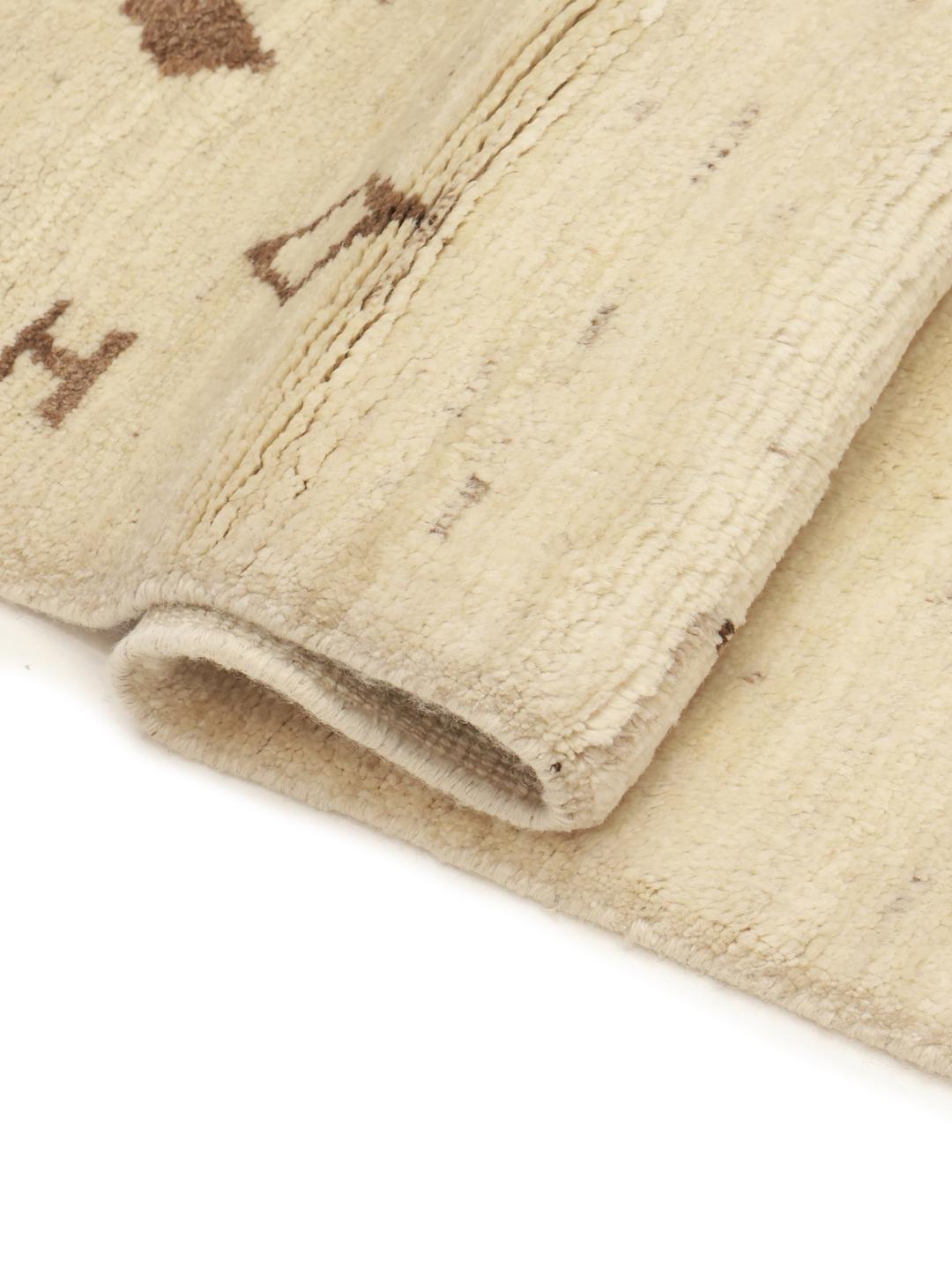 Hand-knotted Afghan wool rug with tribal motifs in a neutral beige tone
