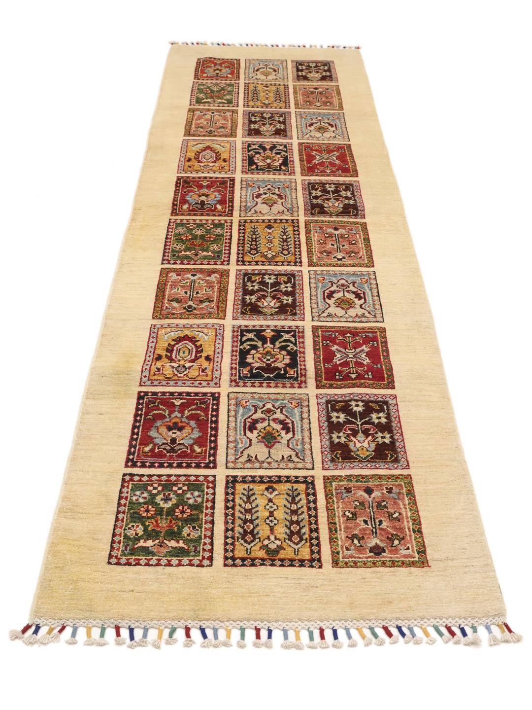 Hand-knotted Afghan runner with colourful floral grid panels on a beige background.