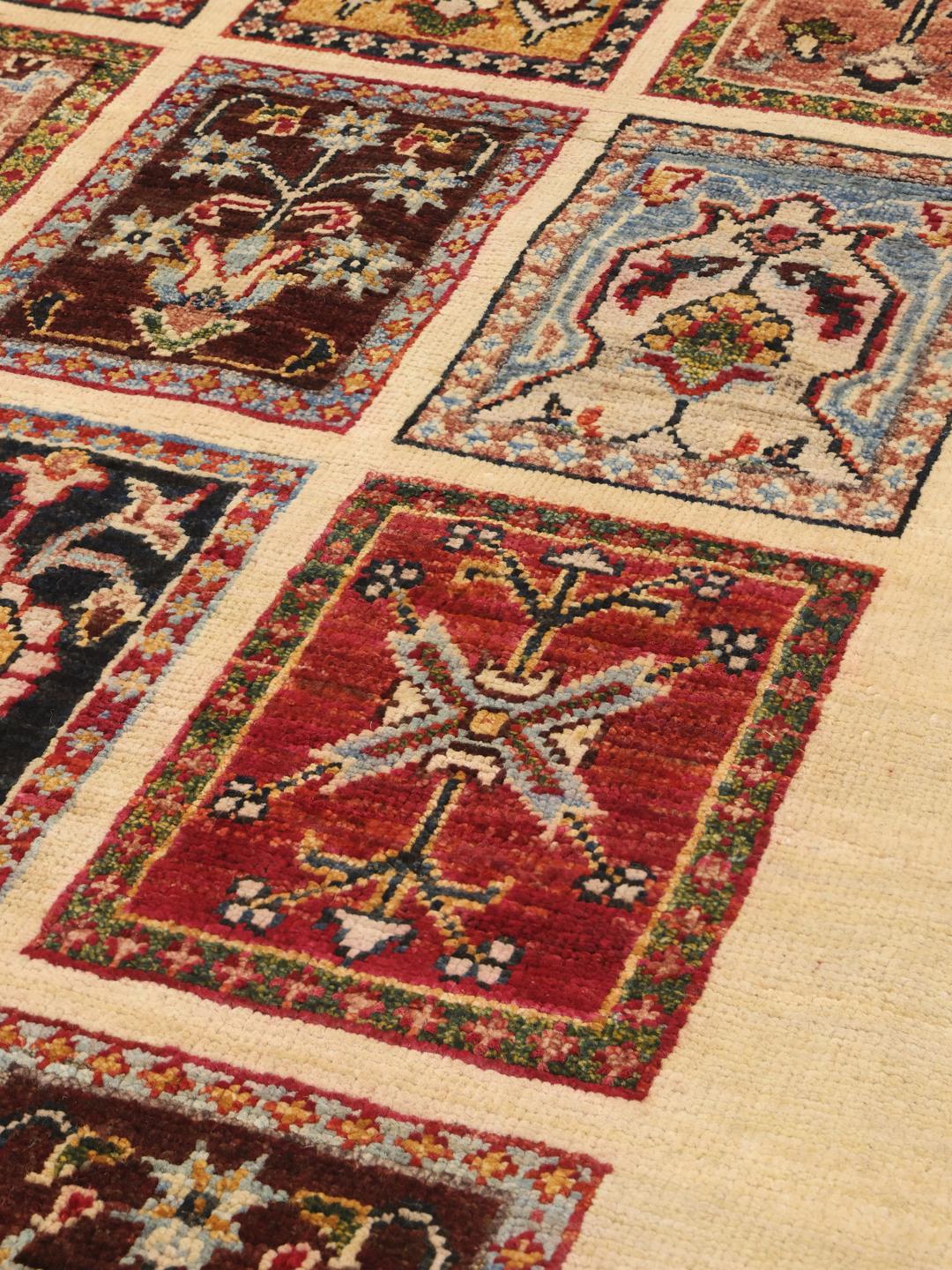 Hand-knotted Afghan runner with colourful floral grid panels on a beige background.