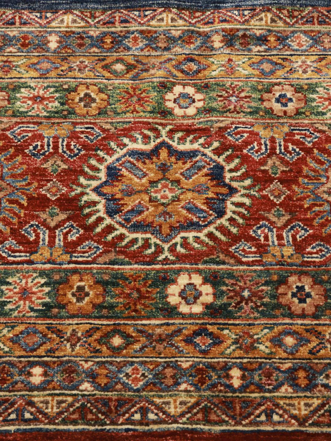 Een handgeknoopte loper uit Afghanistan met een levendig rood en meerkleurig geometrisch ontwerp.