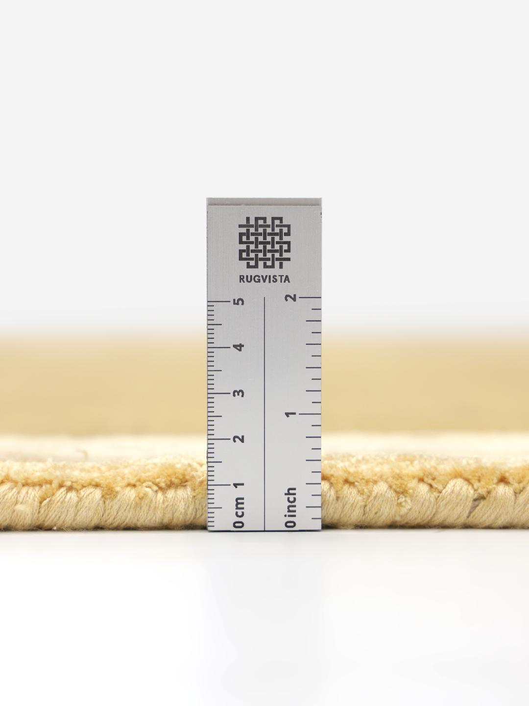 Mosterdgeel wollen tapijt met een decoratieve rand