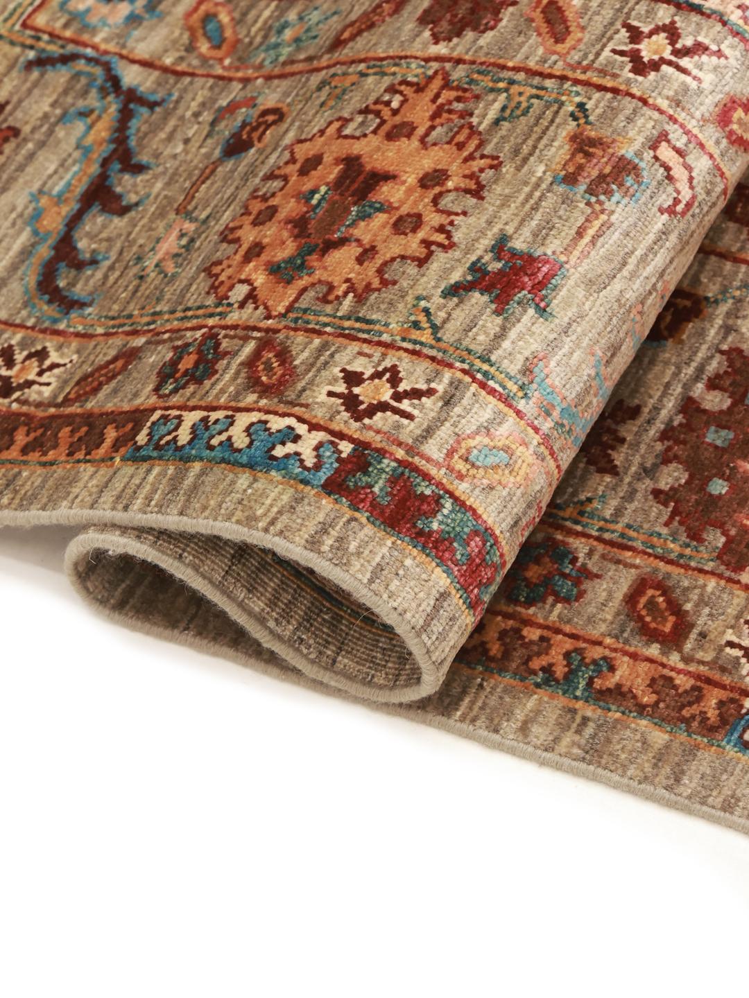 Et håndknyttet afghansk tæppe med blomstermotiver i beige, blå og røde toner.