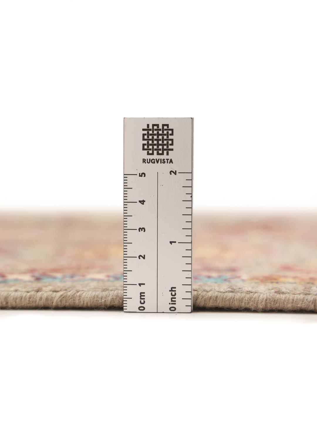 Et håndknyttet afghansk tæppe med blomstermotiver i beige, blå og røde toner.