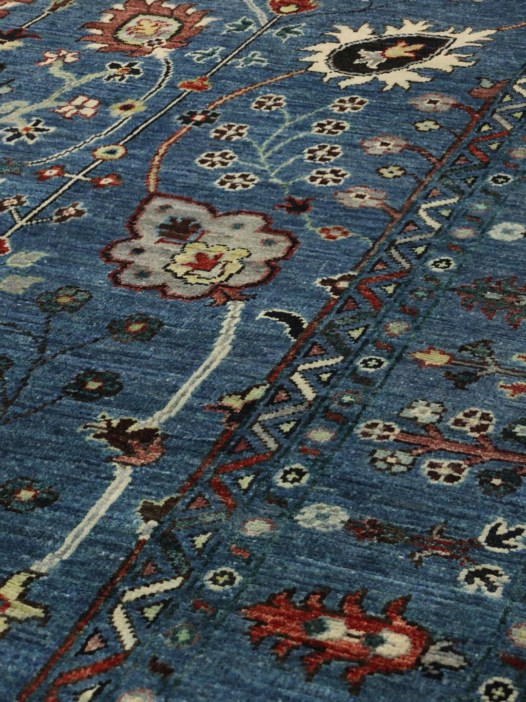Handgeknoopt Afghaans tapijt met een gedetailleerd bloemmotief op een blauwe achtergrond