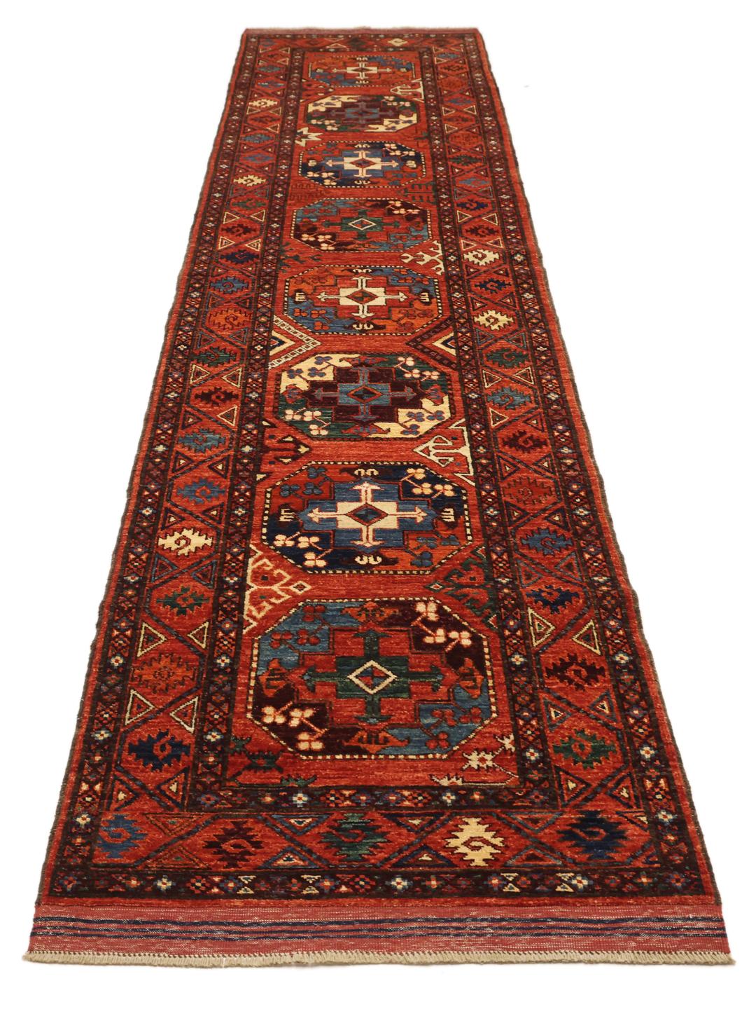 Hand-knotted Panjshir wool runner from the Middle East in red tones.