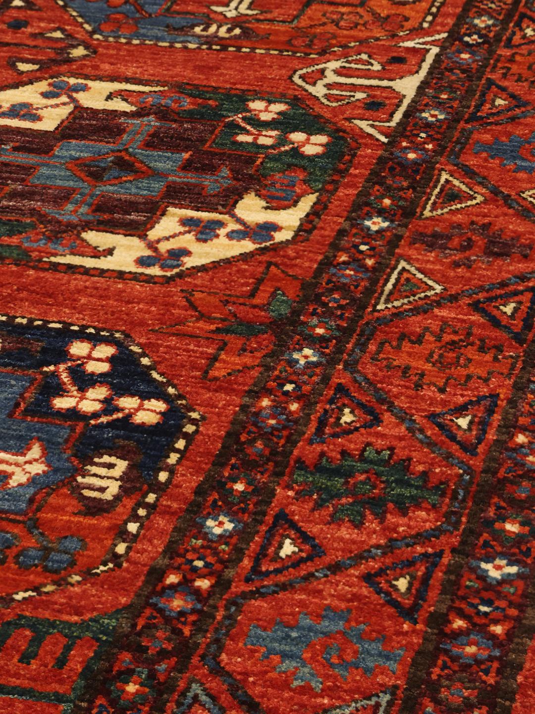 Hand-knotted Panjshir wool runner from the Middle East in red tones.