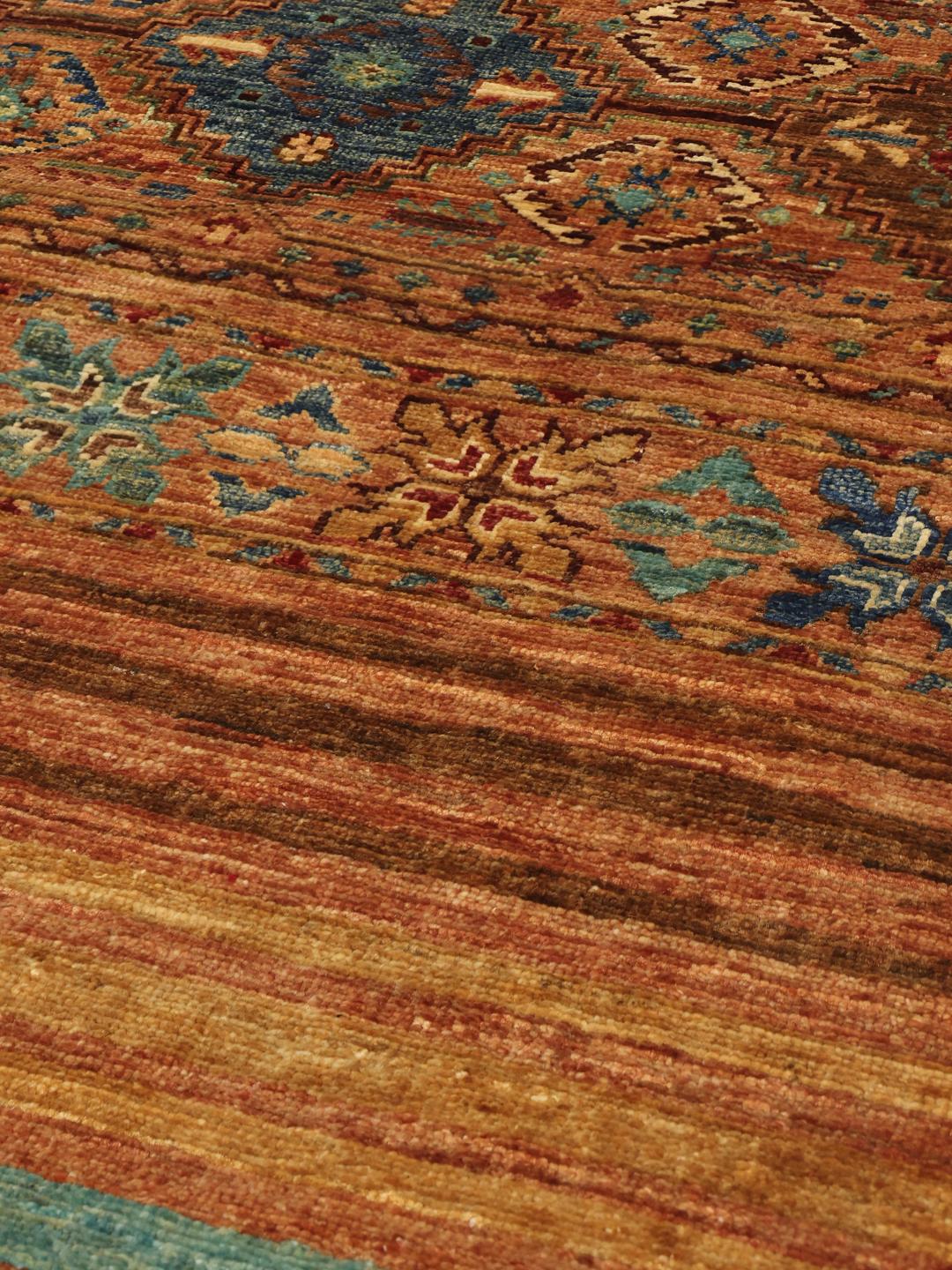 Een lange, handgeknoopte loper uit het Midden-Oosten met tribale geometrische motieven in rode, blauwe en bruine tinten.