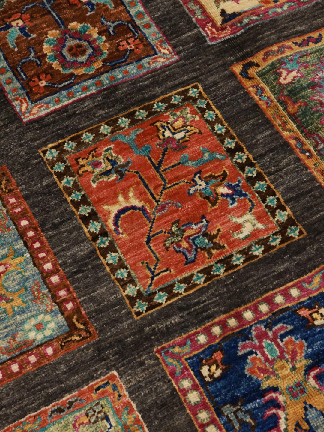Hand-knotted rug from the Middle East featuring a dark field with colourful decorative panels.