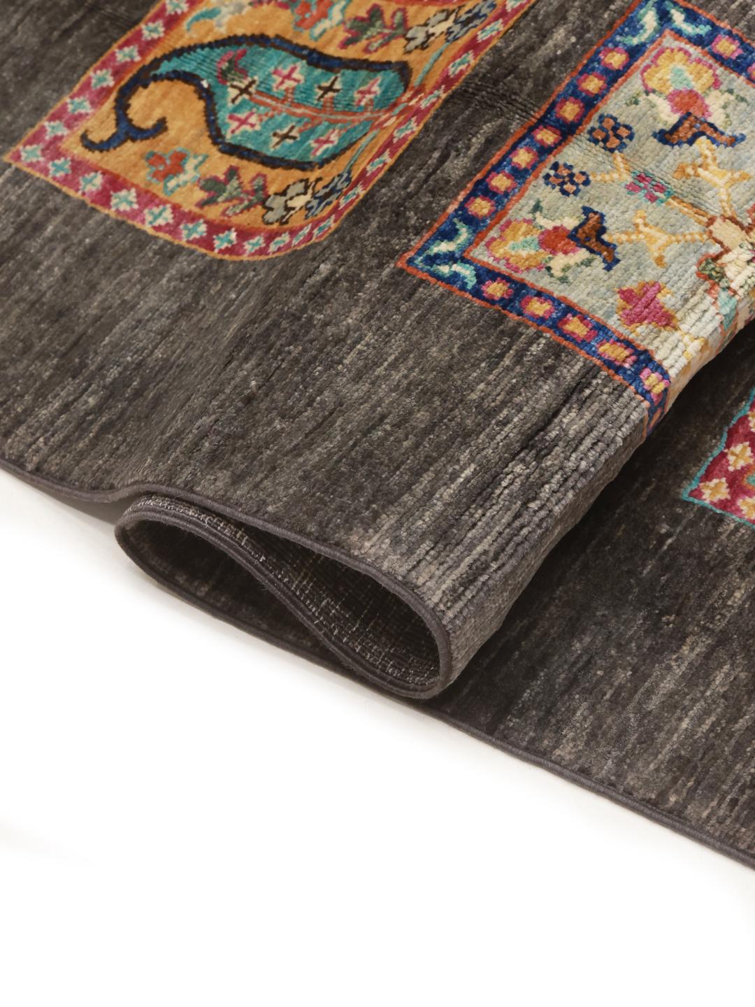 Hand-knotted rug from the Middle East featuring a dark field with colourful decorative panels.