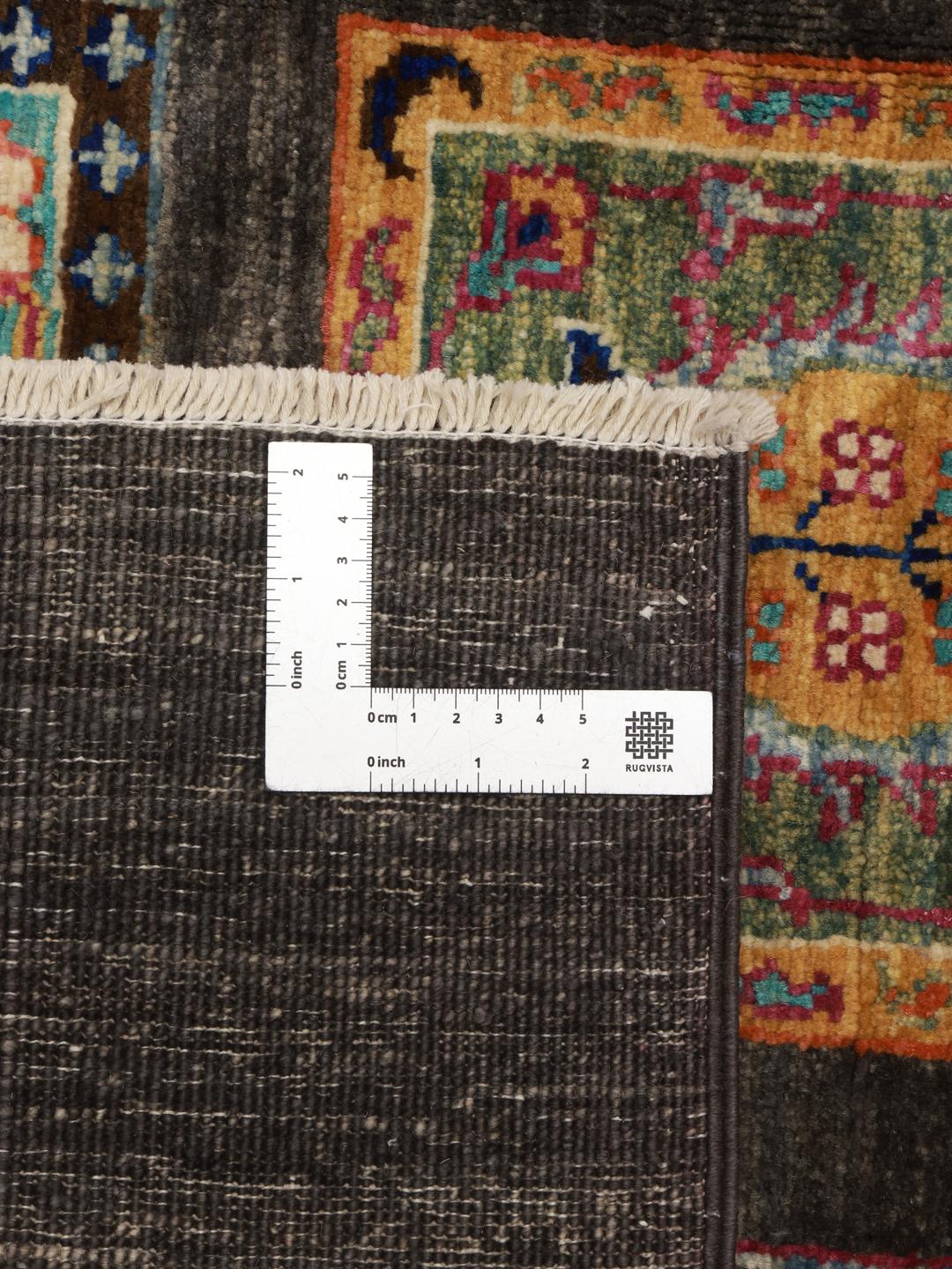 Hand-knotted rug from the Middle East featuring a dark field with colourful decorative panels.