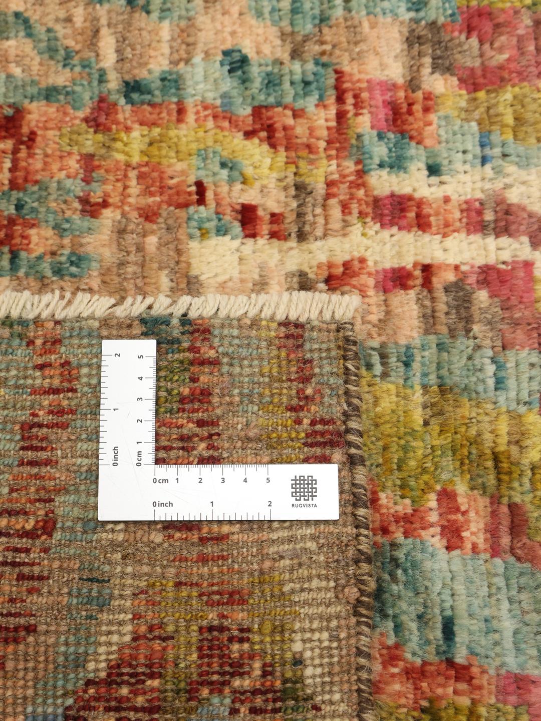 A large, hand-knotted Afghan rug featuring a vibrant, multicolored abstract pattern.
