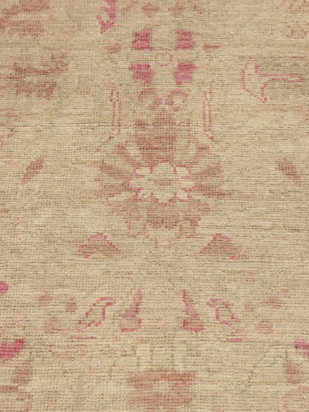 Alfombra Usak anudada a mano de Afganistán con delicados motivos florales en tonos beige y rosa.