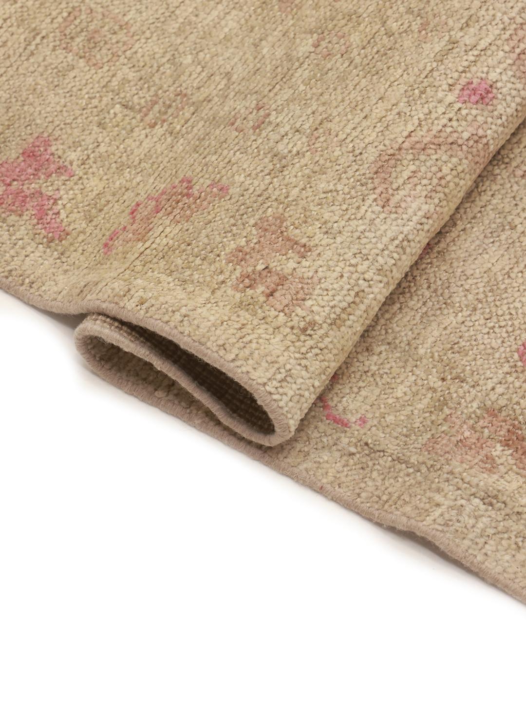 Alfombra Usak anudada a mano de Afganistán con delicados motivos florales en tonos beige y rosa.