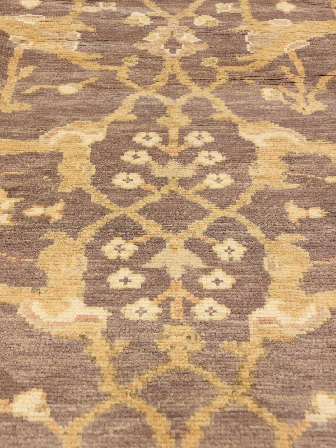 Handgeknoopt Afghaans Usak-tapijt met een bloemenpatroon in bruine en beige tinten.
