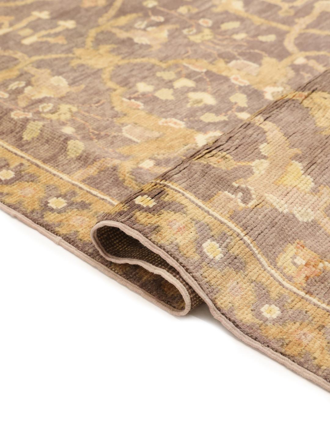 Handgeknoopt Afghaans Usak-tapijt met een bloemenpatroon in bruine en beige tinten.