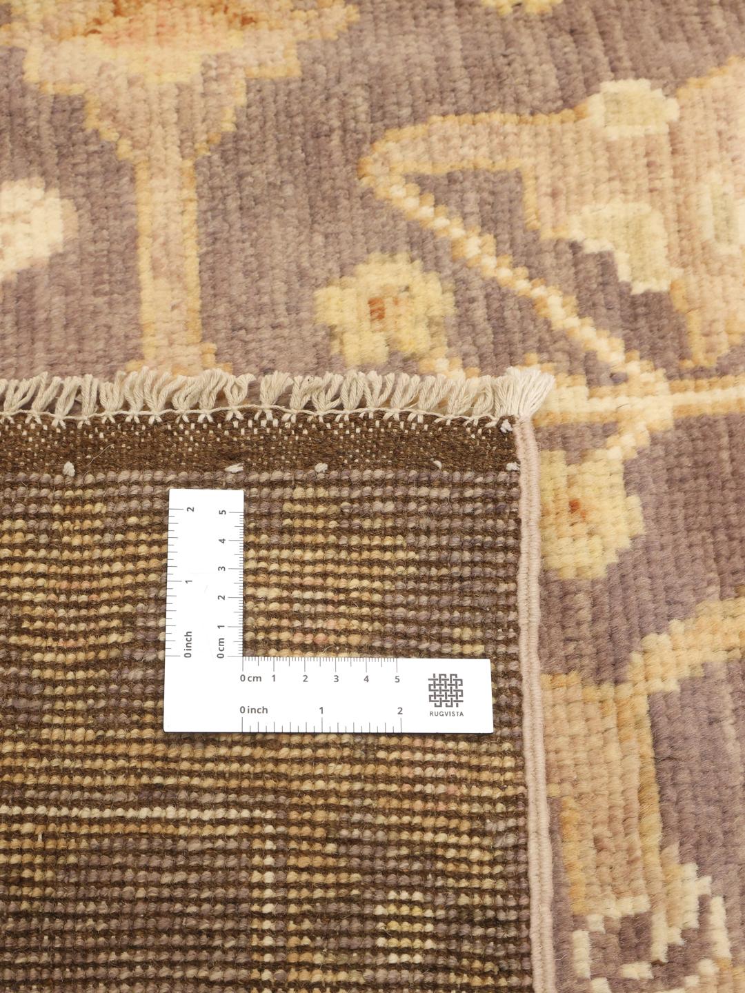 Handgeknoopt Afghaans Usak-tapijt met een bloemenpatroon in bruine en beige tinten.
