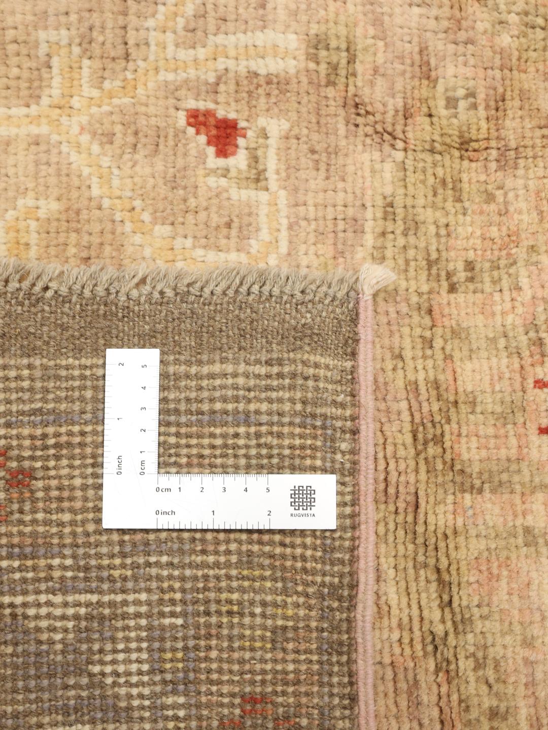 Een groot, handgeknoopt Afghaans Usak tapijt met een zacht beige en meerkleurig botanisch patroon.