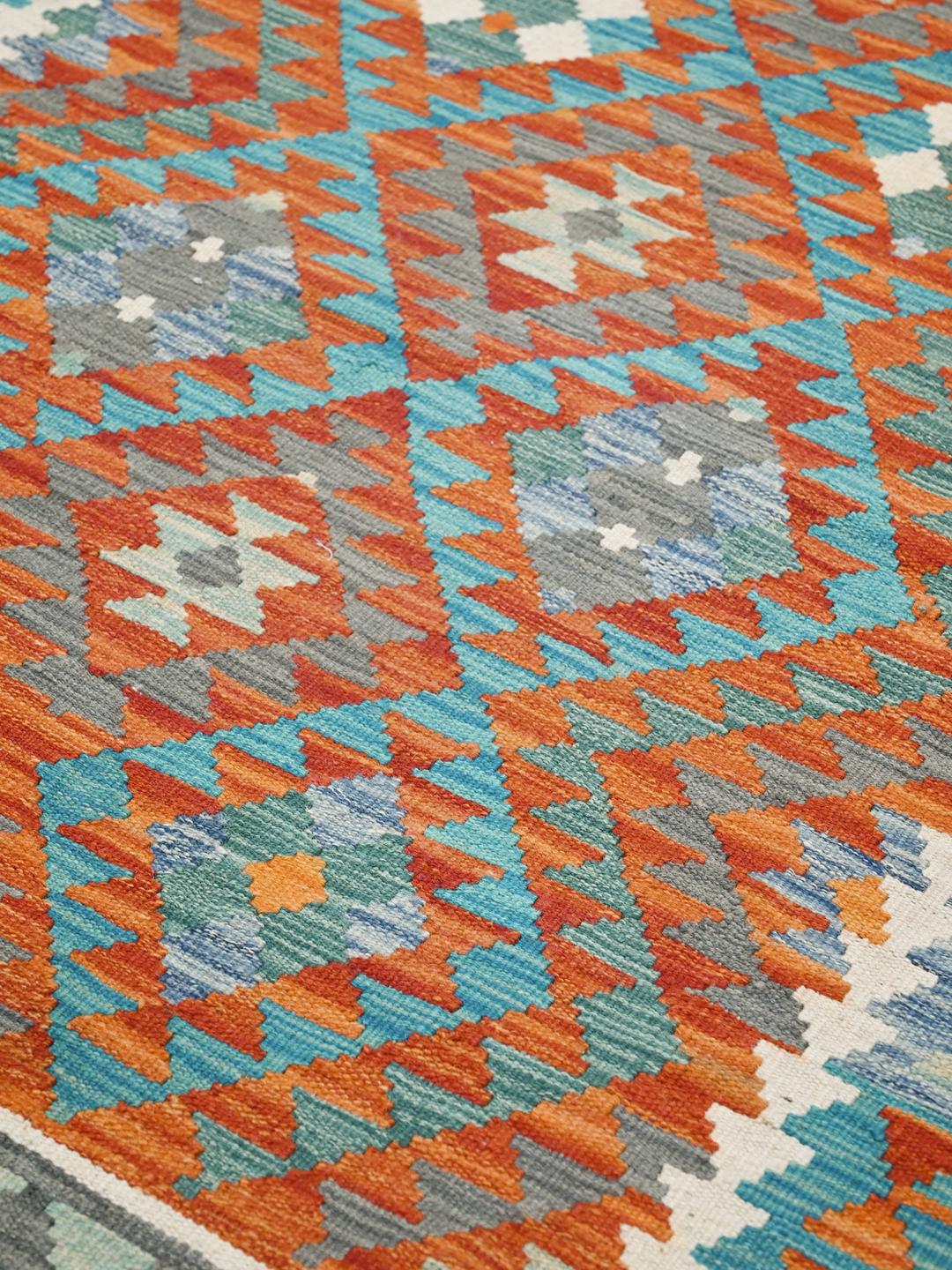 Hand-woven Afghan Kelim rug with geometric diamond patterns in vibrant multicolor tones