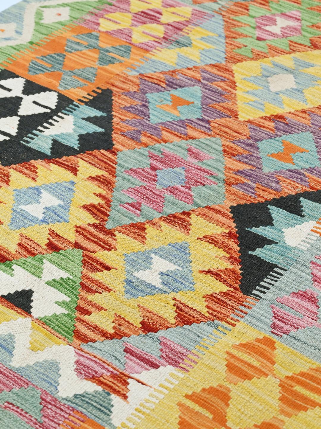 Hand-woven Afghan Kelim rug with a colourful geometric pattern in a rectangular shape.
