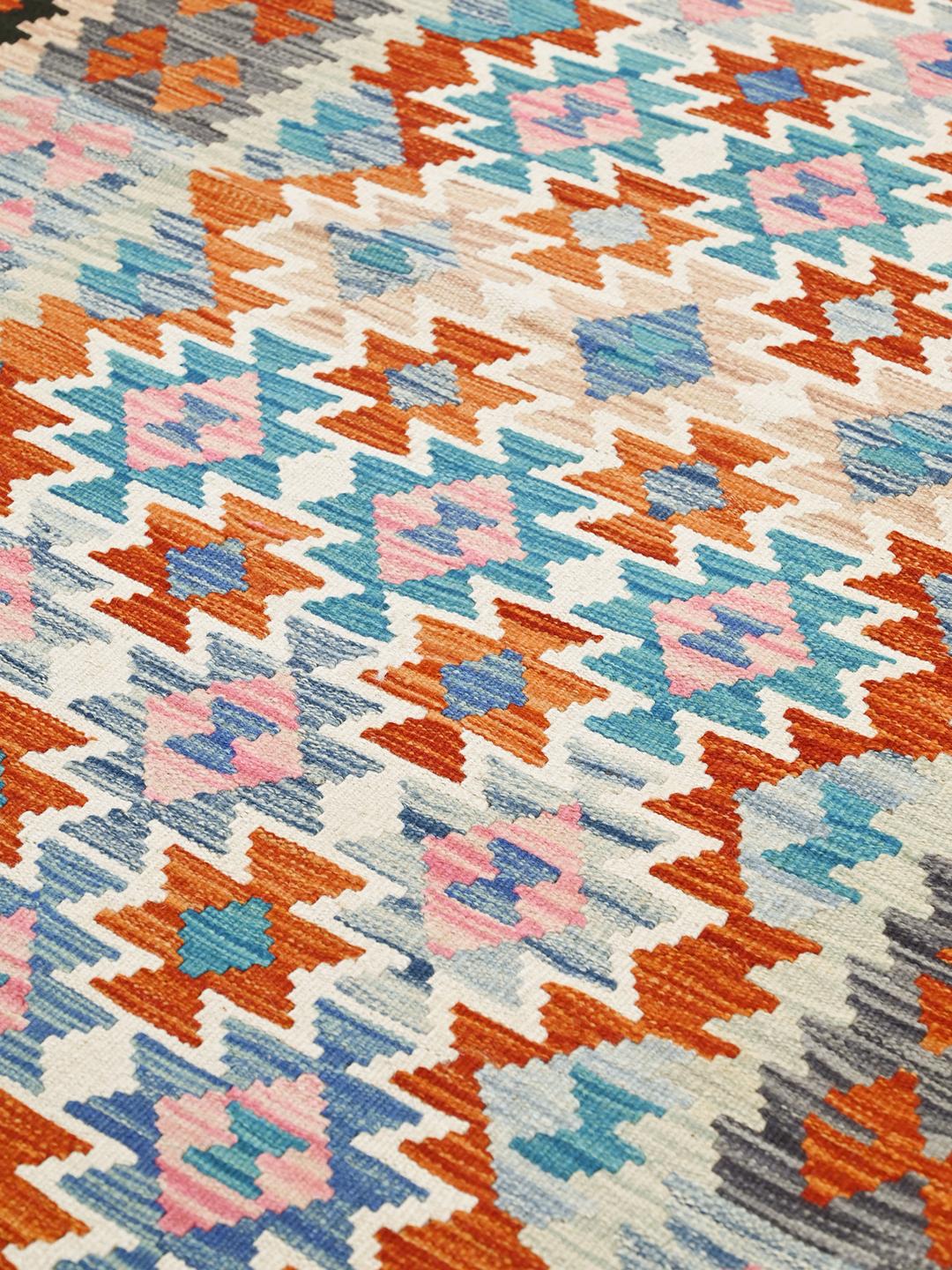 Hand-woven Afghan Kelim rug featuring a vibrant geometric pattern in blue, red, and pink tones.