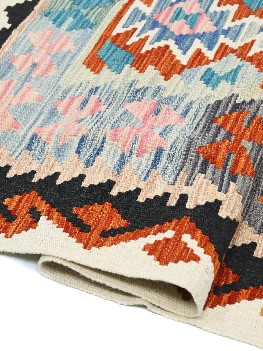 Hand-woven Afghan Kelim rug featuring a vibrant geometric pattern in blue, red, and pink tones.