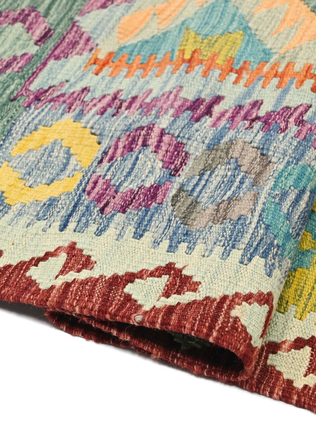 A hand-woven Afghan Kelim rug featuring a vibrant multicolour geometric pattern on a light background.
