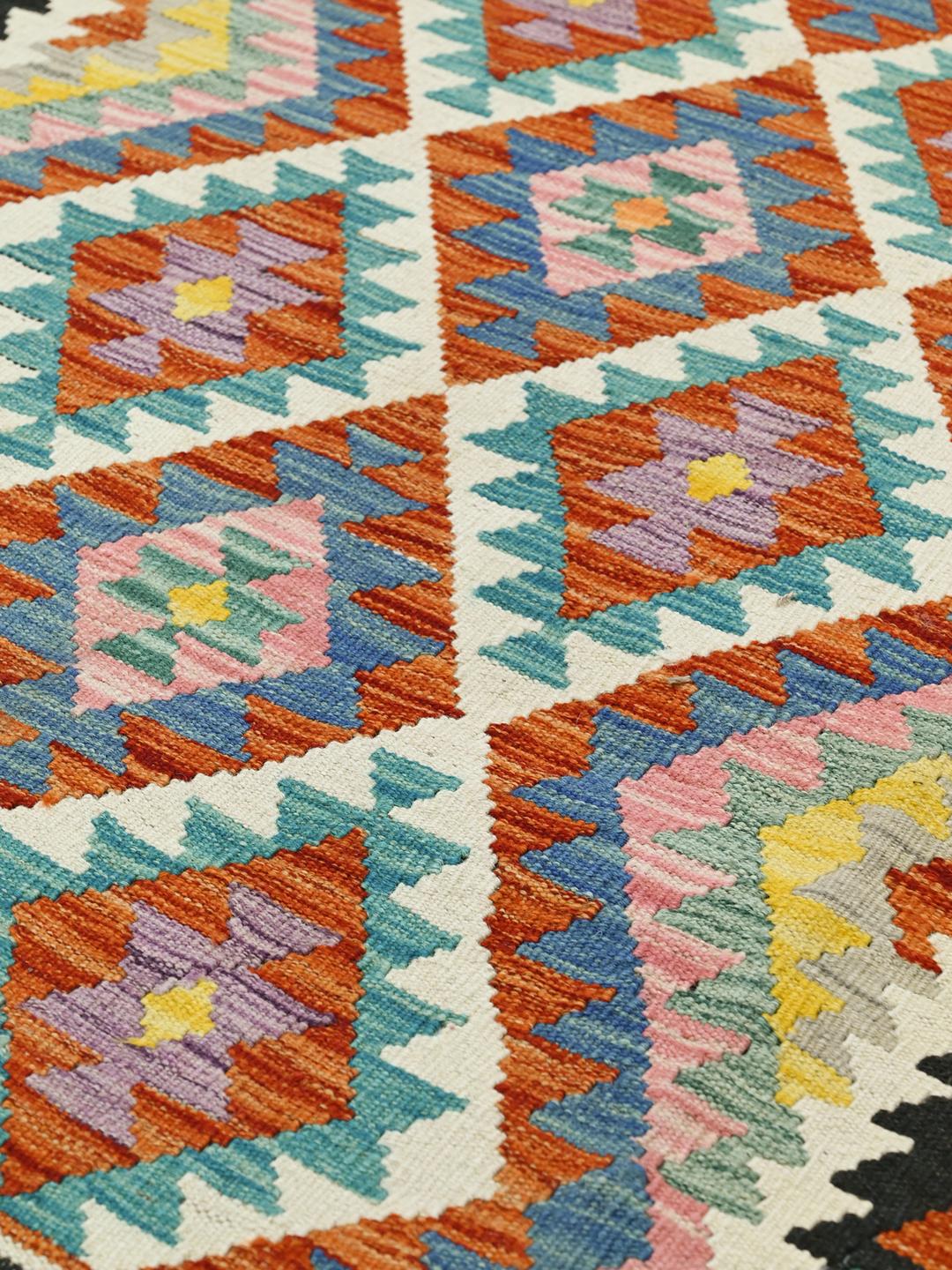 Hand-woven Afghan Kelim rug featuring a colourful geometric design with diamond motifs