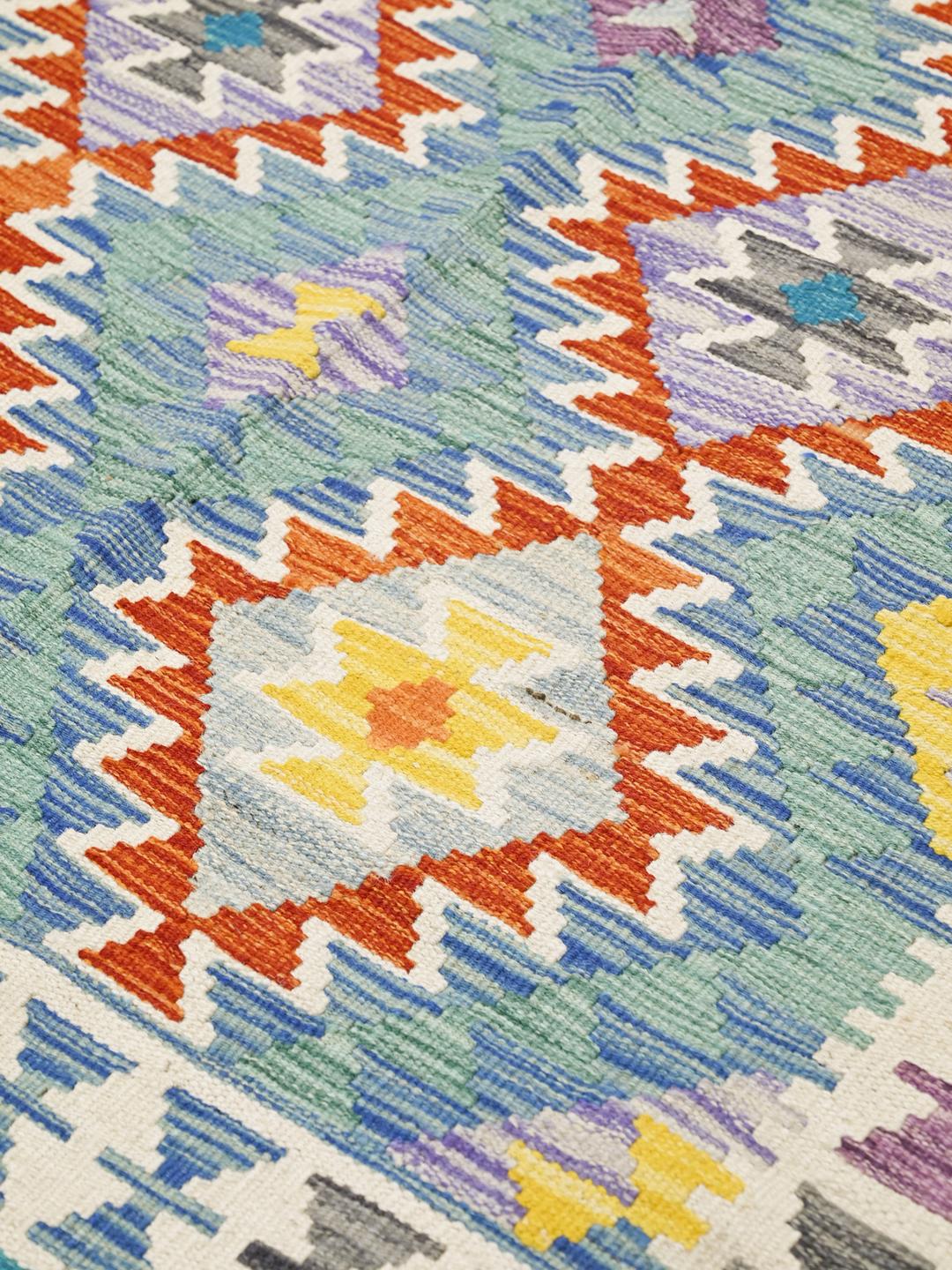 A hand-woven Kelim Afghan rug from the Middle East with vibrant multicolor geometric patterns.