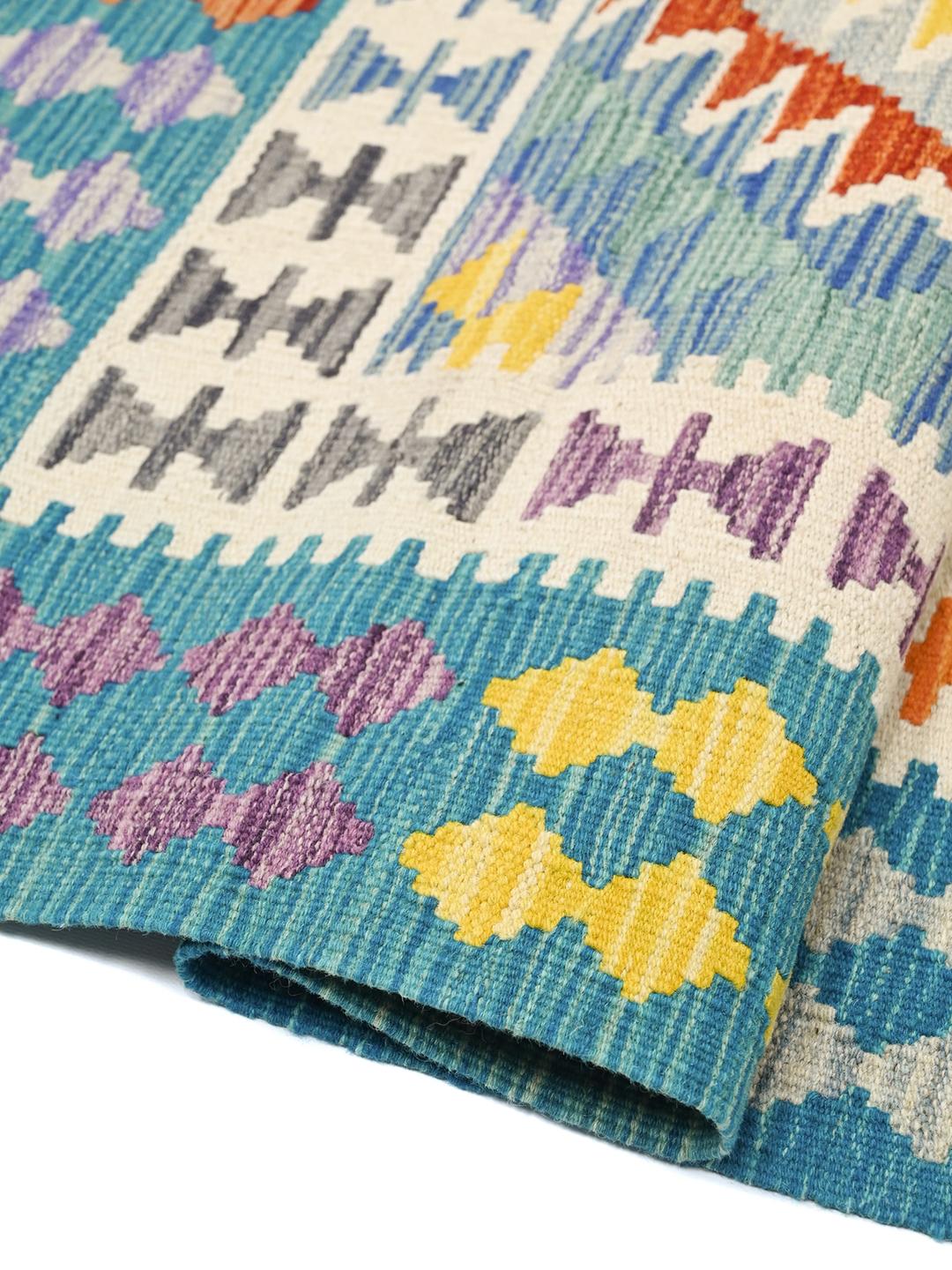 A hand-woven Kelim Afghan rug from the Middle East with vibrant multicolor geometric patterns.