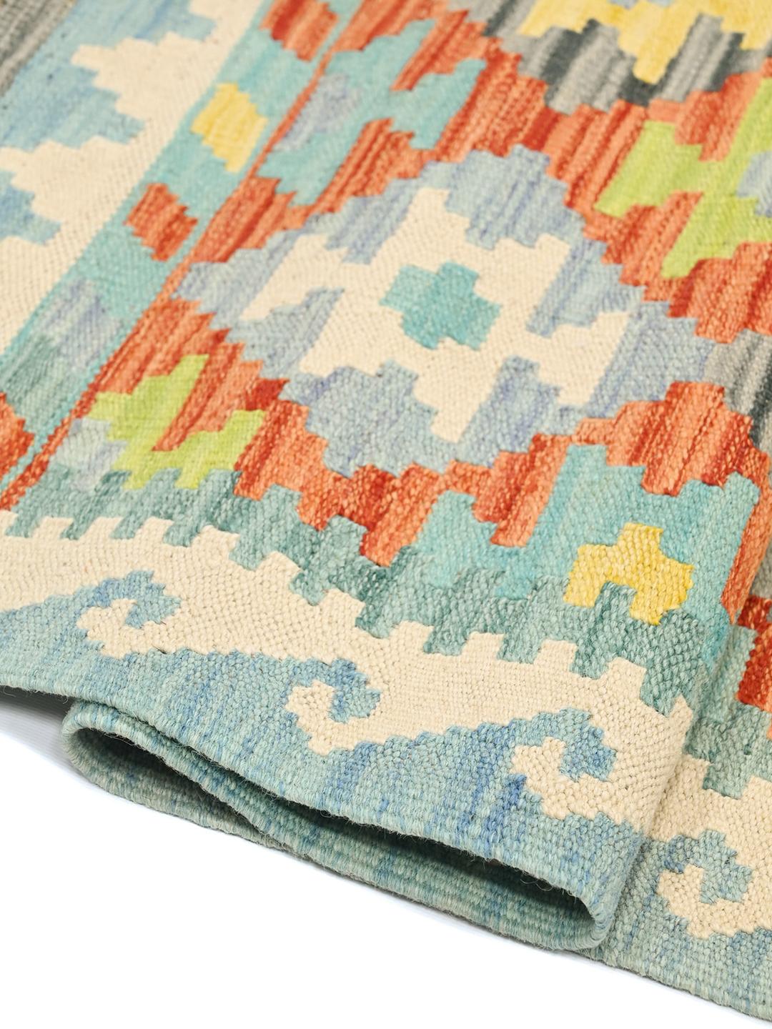 Runner afghano tessuto a mano con un vivace motivo geometrico a losanghe in lana multicolore.