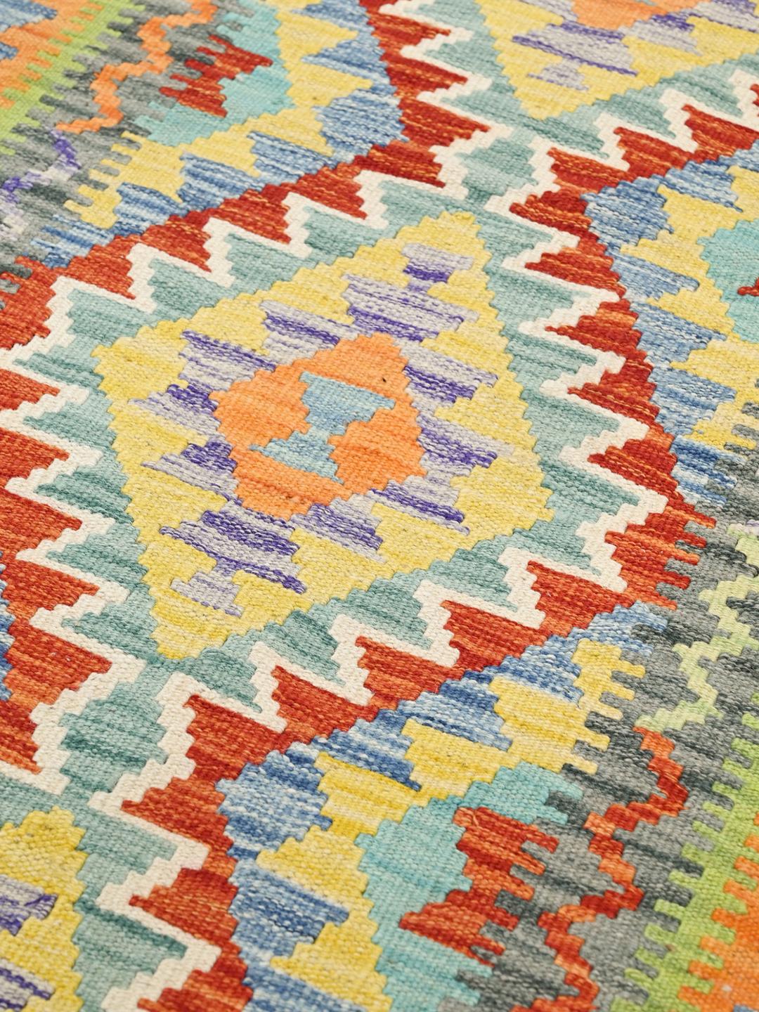 Runner afghano tessuto a mano con motivi geometrici colorati in lana multicolore.